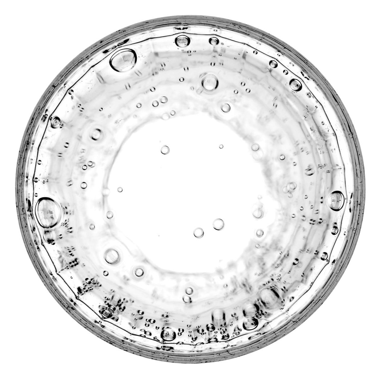 Transparente Flüssigkeit mit aufsteigenden Blasen in einer Glasschale – Symbol für Reinheit, Präzision und bioaktive Formulierungen der PDB Supplements.